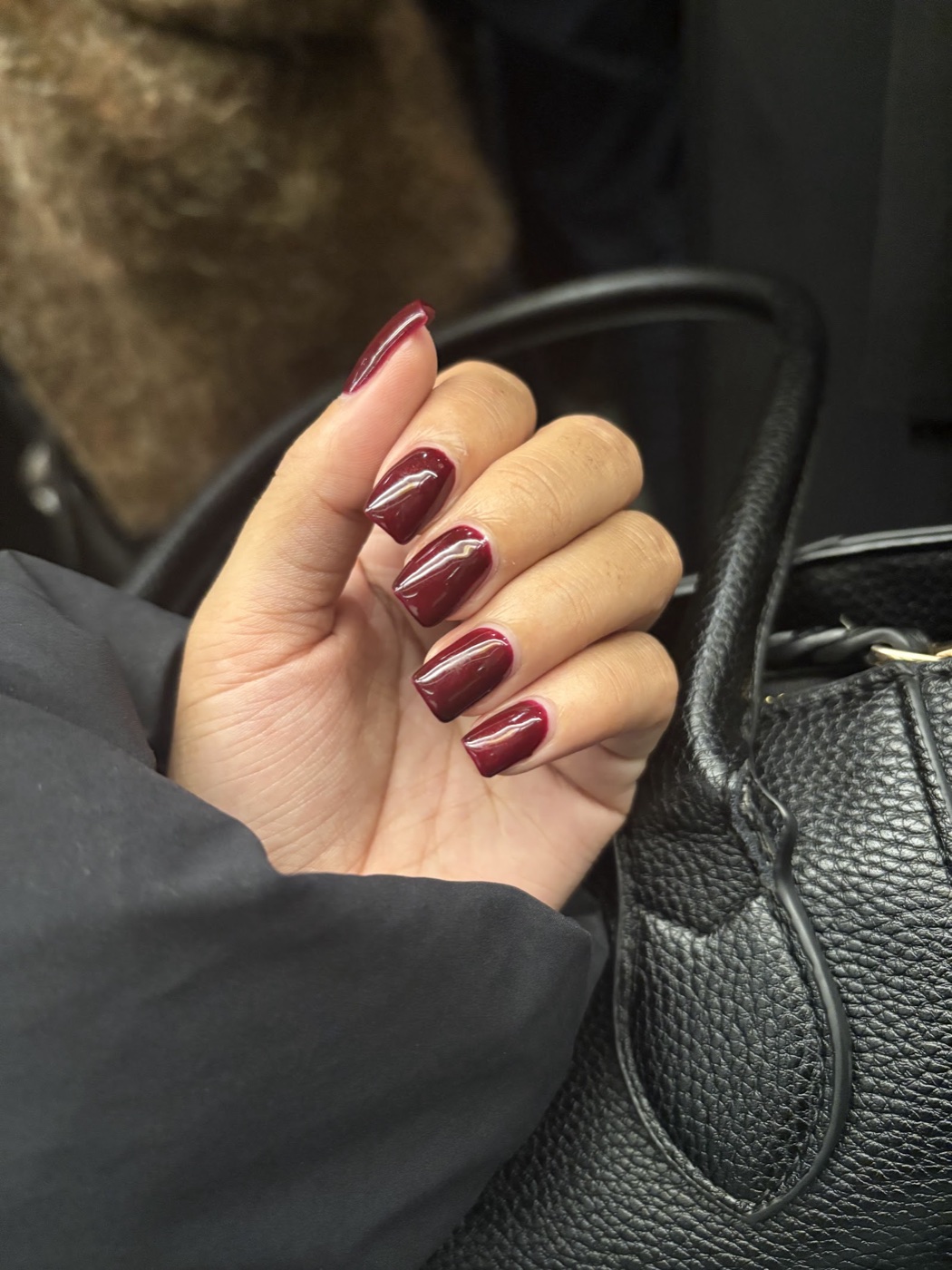 Square-shaped nails in a deep glossy burgundy gel polish